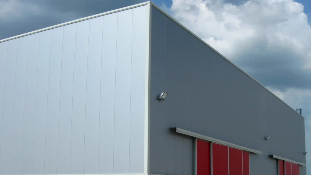 Zdjęcie przedstawia obróbki blacharskie zamontowane na hali przemysłowej