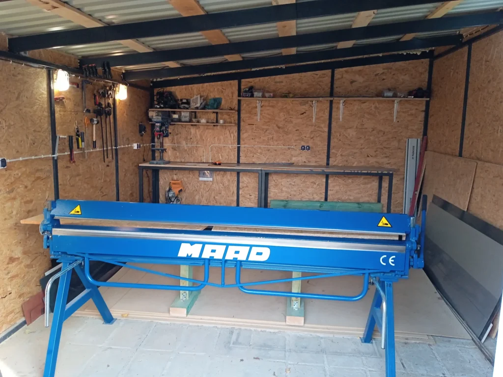 Zaginarka, na której gięte są obróbki blacharskie – zdjęcie urządzenia. Fotografia przedstawia maszynę używaną do precyzyjnego gięcia blach, wykorzystywaną w produkcji elementów dachowych i konstrukcyjnych.